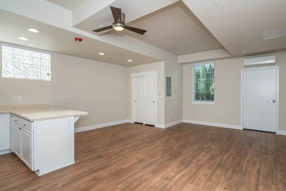 A room with a ceiling fan and wooden flooring.