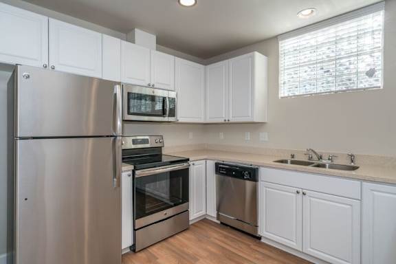 A kitchen with white cabinets and stainless steel appliances.