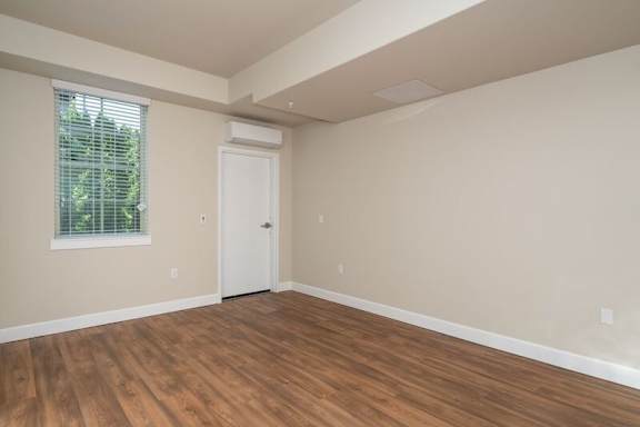 A room with a white door and a window with blinds.
