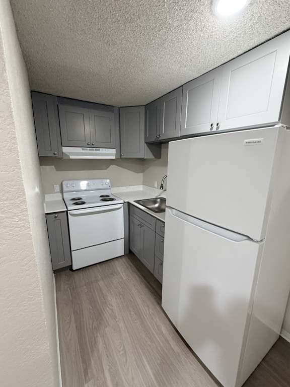A white refrigerator is in a kitchen with white appliances.