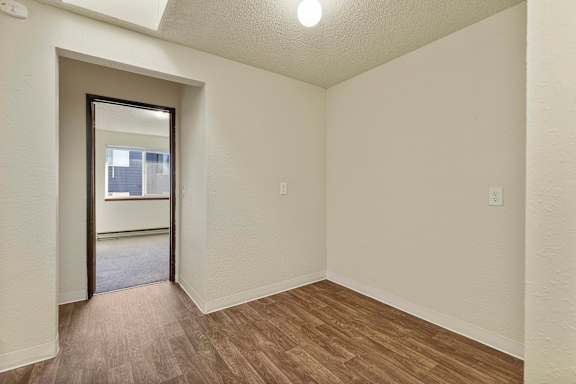 A room with a wooden floor and a door leading to a balcony.
