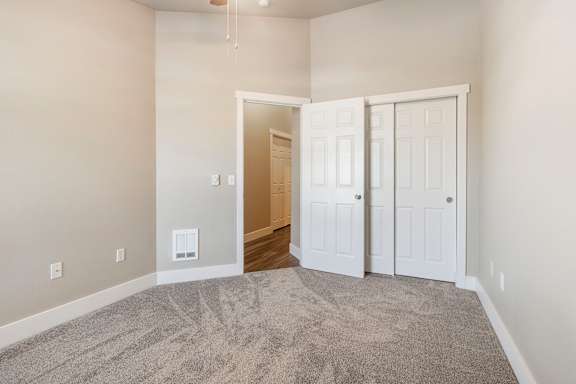 A room with a carpeted floor and two white doors.