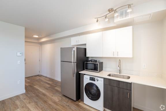 Modern 1Bed/1Bath Kitchen with stainless steel refrigerator and microwave, and a washer/dryer combo