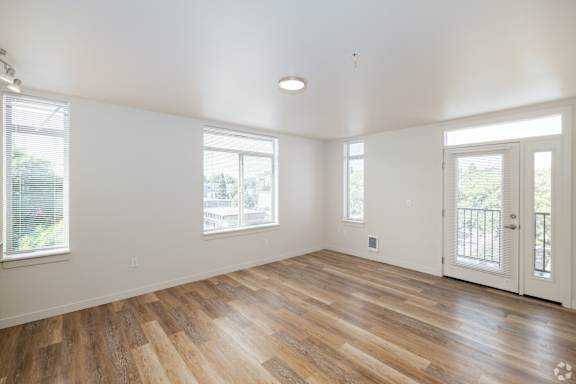 Living room in 1-bedroom apartment at Bode 125 with luxury vinyl wood plank floors, white walls, and multiple windows
