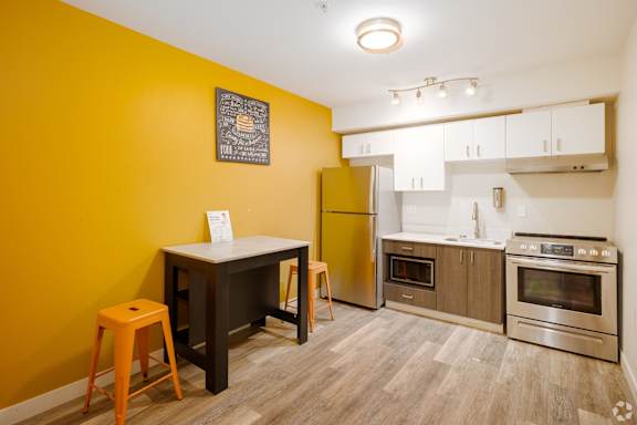 A kitchen with yellow walls and stainless steel appliances.