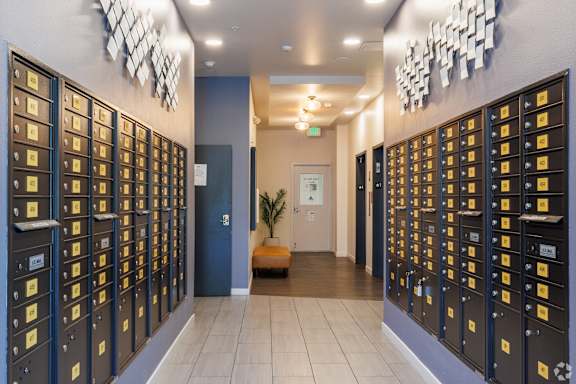 A hallway with a series of mailboxes on the wall.