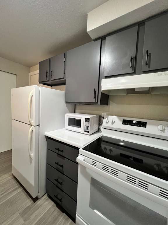 A kitchen with white appliances and cabinets.