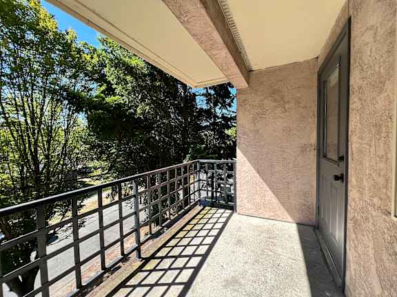 A balcony with a metal railing and a door on the right side.