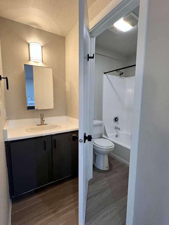 A bathroom with a toilet, sink, and mirror.