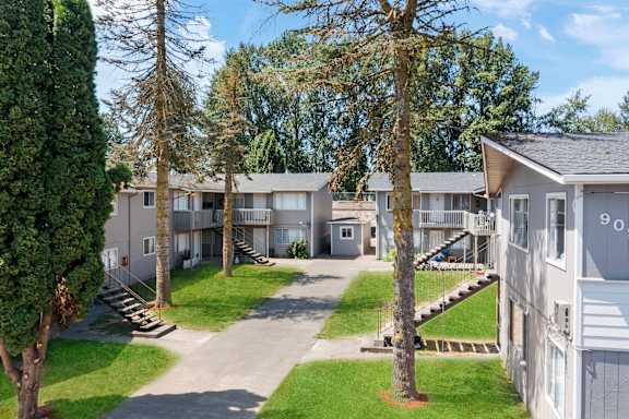 A sunny day at the apartment complex with trees and well-kept lawns.