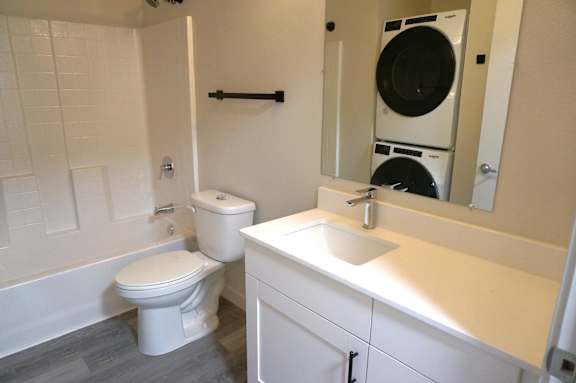 A white toilet and sink in a bathroom.