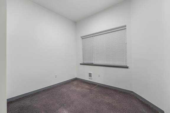 a small room with a window and a carpeted floor