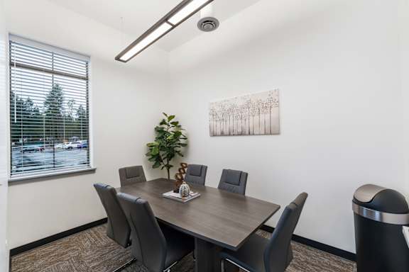 A conference room with a large table and chairs.