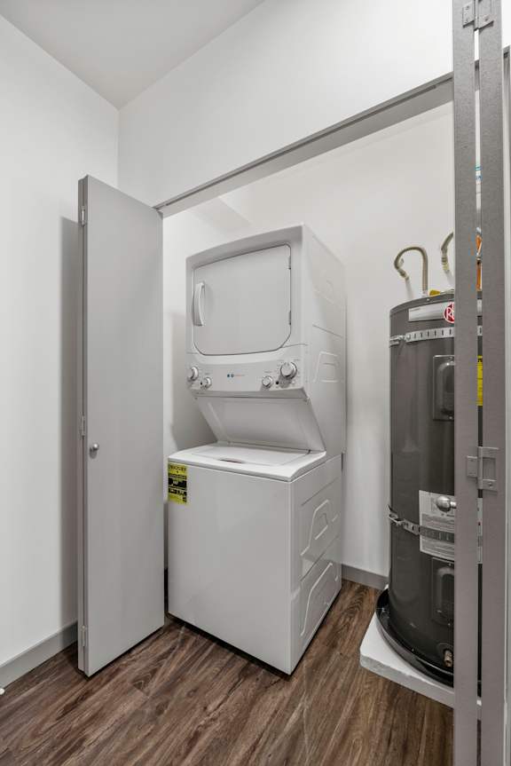 A small white washing machine is in a small room.