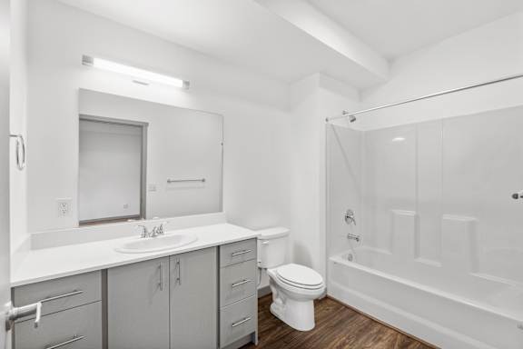 A white bathroom with a toilet, sink, and bathtub.