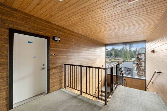A room with a wooden ceiling and a white door.