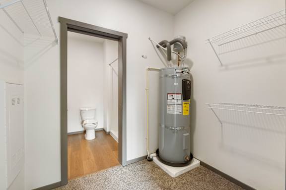 A room with a toilet, a heater and a door.