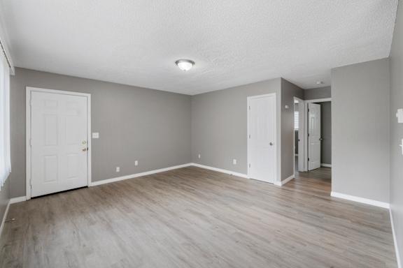 A room with a white door and a grey wall.