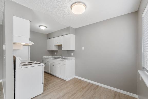 A small kitchen with white appliances and cabinets.