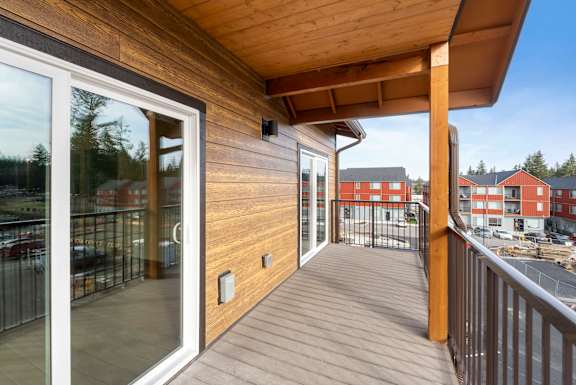 A balcony with a sliding glass door and a wooden railing.
