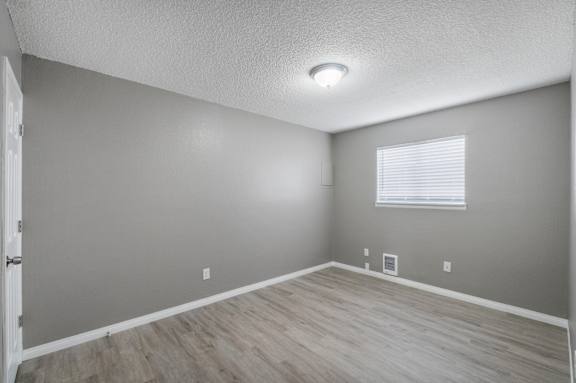 A room with a window and wooden flooring.