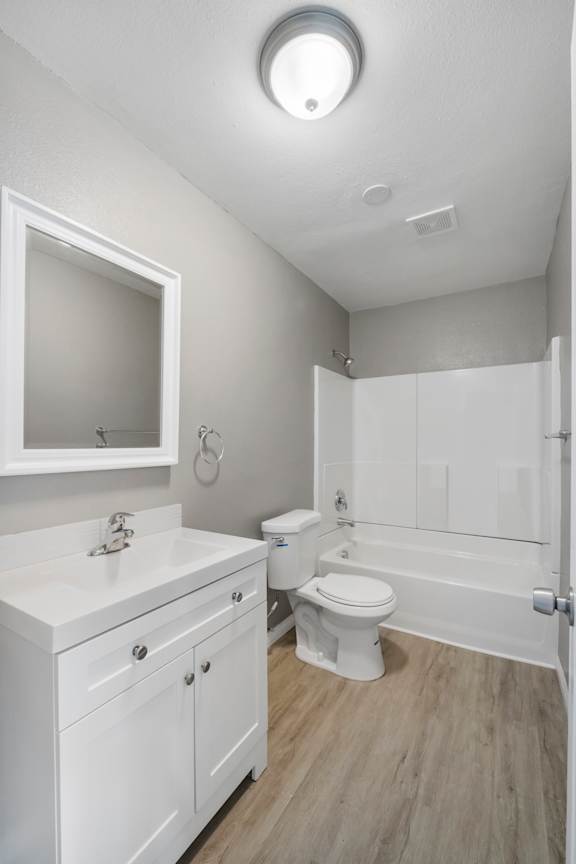 A white bathroom with a toilet, sink, and bathtub.
