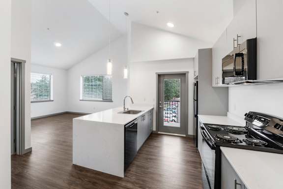 a kitchen with white walls and a wooden floor