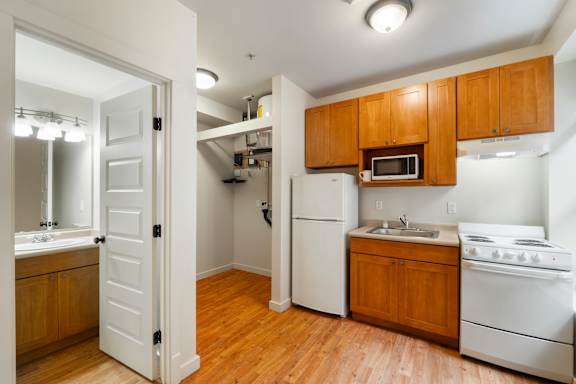A kitchen with white appliances and wooden cabinets.