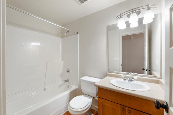 A white bathroom with a toilet, sink, and bathtub.