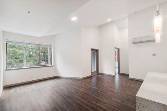 A large empty room with wooden floors and white walls.