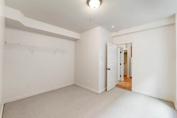 A white room with a door and a light on the ceiling.