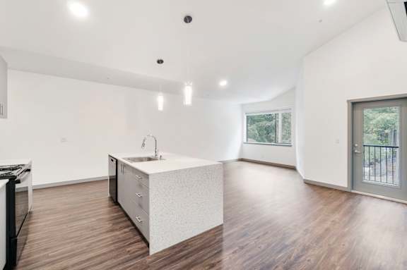 A modern kitchen with a white countertop and wooden flooring.