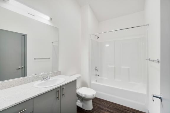A white bathroom with a toilet, sink, and bathtub.