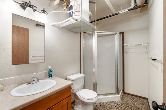 A bathroom with a toilet, sink, and shower.