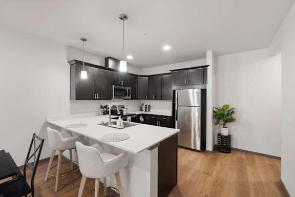 A modern kitchen with a white table and black cabinets.