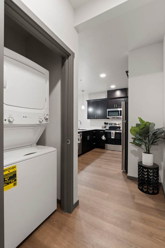 A modern kitchen with a washing machine in the doorway.