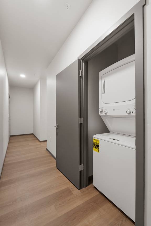 A modern kitchen with a white oven and a wooden floor.
