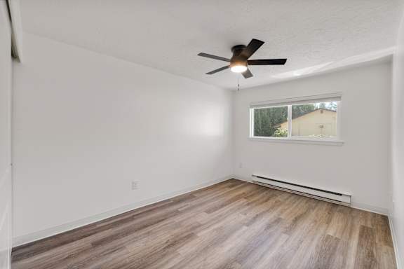A room with a ceiling fan and a window.