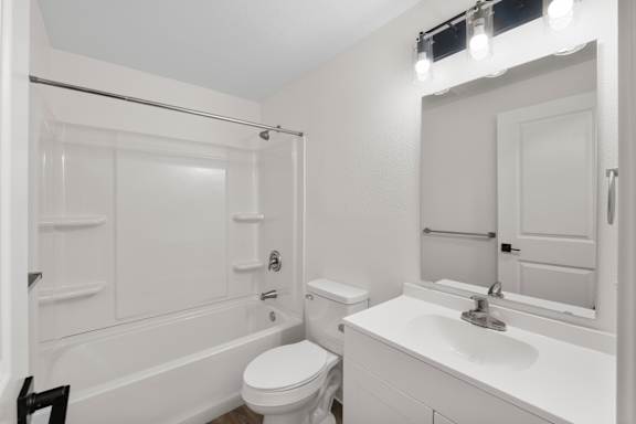 A white bathroom with a toilet, sink, and bathtub.