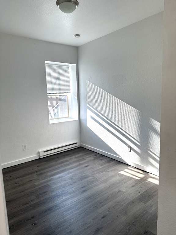 Bedroom with window, natural light, and baseboard heating in Olympia WA apartment