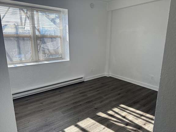 Living room with large window and baseboard heater in Olympia Washington apartment