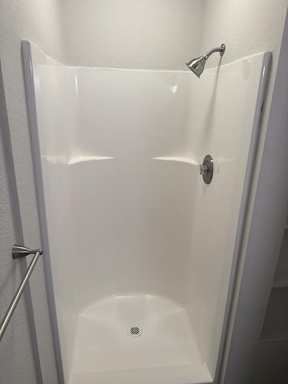 shower with white surround and chrome fixtures in Olympia WA apartment at The Elks Apartments