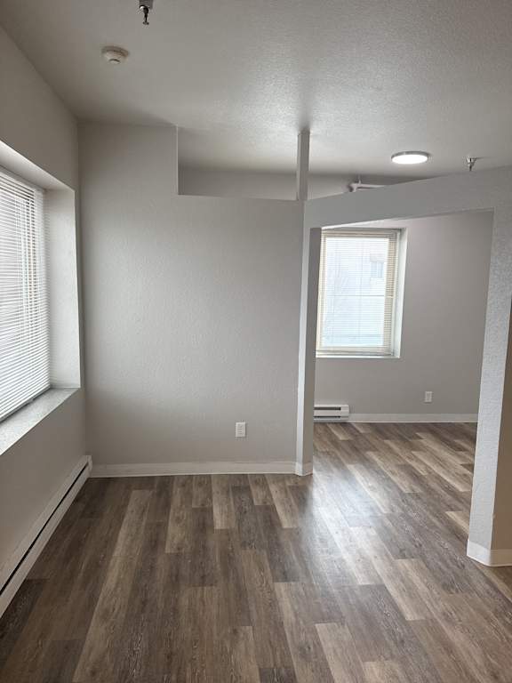 A room with wooden flooring and a window.
