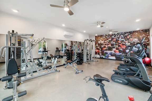 A spacious home gym with a variety of exercise equipment at The Hub Apartments, Lacey