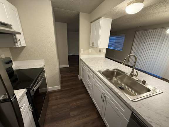 Floor Plan  A kitchen with white cabinets and a stainless steel sink.