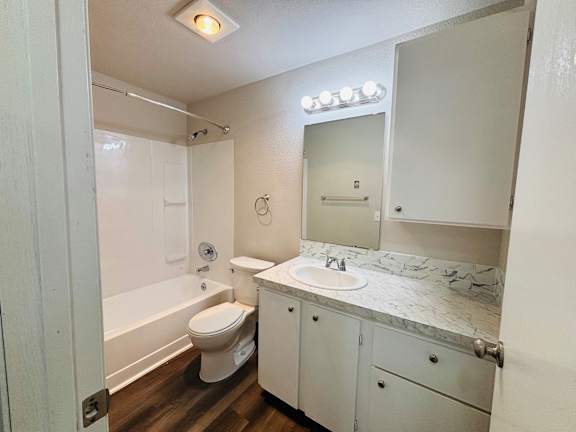 A white bathroom with a sink, toilet, and mirror.