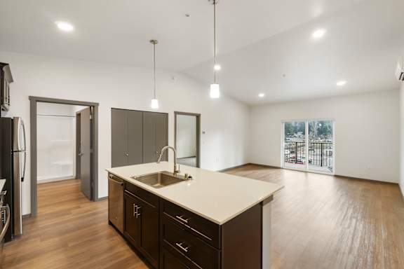 A kitchen with dark wood cabinets and a white countertop.