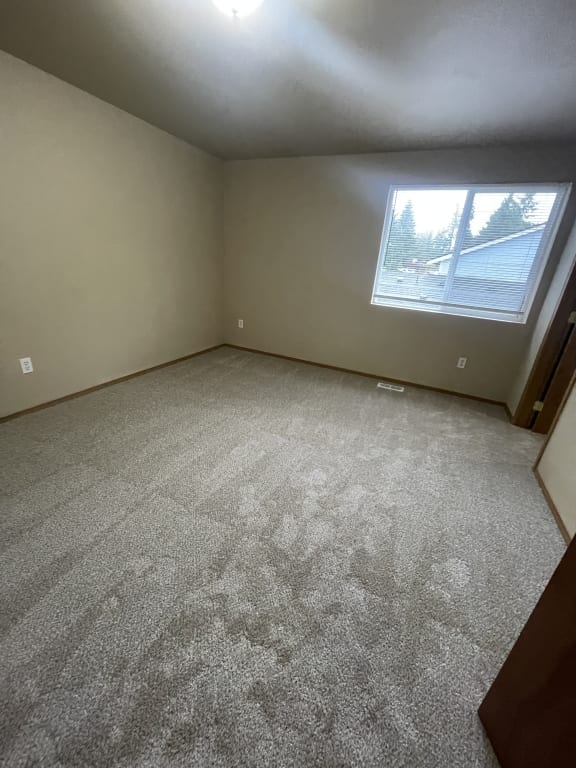 a room with a window on the wall and a staircase