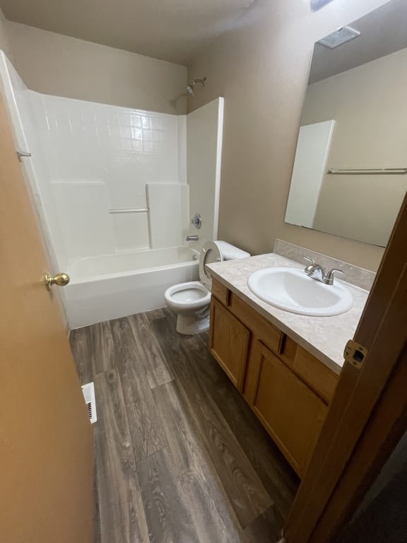 a bathroom with a toilet and a sink and a wooden vanity