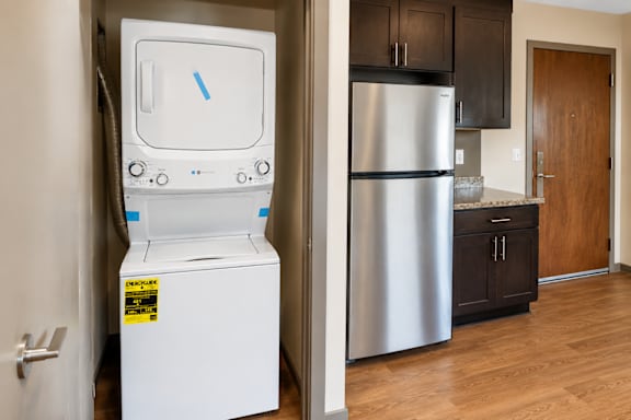A white microwave oven is on the left and a stainless steel refrigerator is on the right.